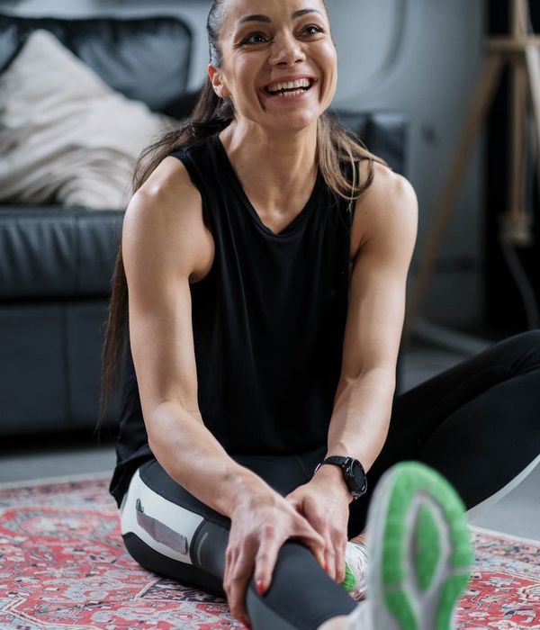 Smiling woman stretching gently, embodying energy and vitality.